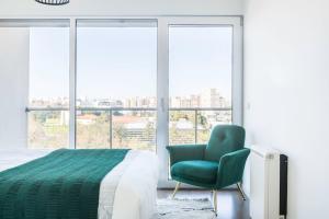 a bedroom with a bed and a chair and windows at Amazing Flat - Pool and Parking in Lisbon +25 photos