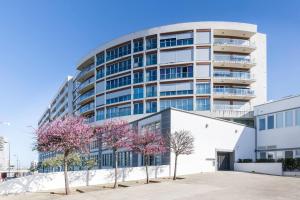 a tall building with trees in front of it at Amazing Flat - Pool and Parking in Lisbon