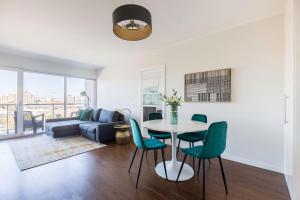a living room with a table and chairs and a couch at Amazing Flat - Pool and Parking in Lisbon
