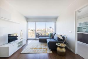 a living room with a couch and a tv at Amazing Flat - Pool and Parking in Lisbon