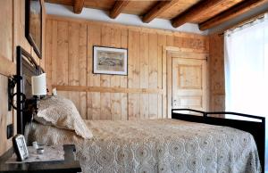 a bedroom with a bed and a wooden wall at B&B Aquarelle in Faggeto Lario 