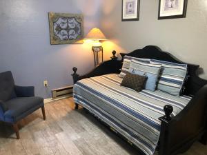 a bedroom with a bed and a chair and a lamp at Ramsey Canyon B&B Apartment Suites in Nicksville