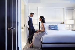 a man and woman are standing in a bedroom at Fairmont Royal York Gold Experience in Toronto