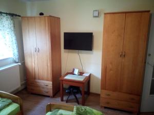 チュウフフにあるMieszkanie na zielonejのベッドルーム1室(木製キャビネット、テーブル、テレビ付)