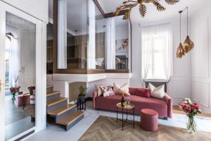 a living room with a red couch and stairs at Fragola Apartments Old Town in Krakow