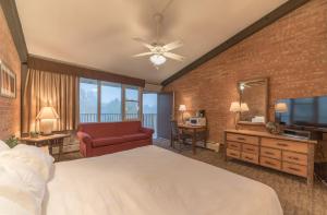 a bedroom with a large bed and a red chair at Mountain Chalet Snowmass in Snowmass Village