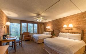 a hotel room with two beds and a balcony at Mountain Chalet Snowmass in Snowmass Village