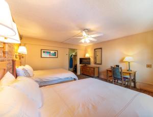 a bedroom with two beds and a ceiling fan at Mountain Chalet Snowmass in Snowmass Village