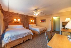 a hotel room with two beds and a table at Mountain Chalet Snowmass in Snowmass Village
