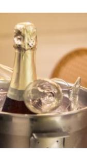 Una botella de champán en una olla sobre una mesa en Vila 57 HOTEL, en Tirana