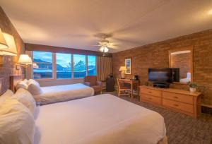 a hotel room with two beds and a flat screen tv at Mountain Chalet Snowmass in Snowmass Village +37 photos
