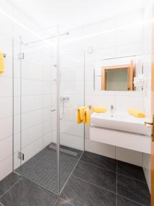 a bathroom with a glass shower and a sink at Ferienhaus Stefanie in Sankt Kanzian