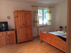 ein Schlafzimmer mit einem Bett, einer Kommode und einem Fenster in der Unterkunft FeWo Wende in Heringsdorf