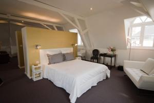 a bedroom with a large white bed and a couch at Chambres d'Hôtes Les Tilleuls in Cognac