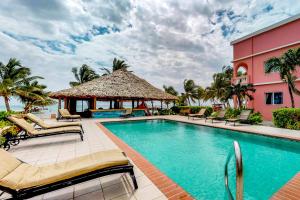 - une piscine dans un complexe avec des chaises et un kiosque dans l'établissement Seaview - Caribe Island, à San Pedro