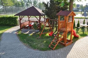 um parque infantil com um escorrega e um baloiço em Willa pod Brzozami em Niechorze
