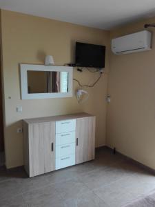 Zimmer mit einem Schrank mit einem Spiegel und einem TV in der Unterkunft Villa Cazala in Monemvasia
