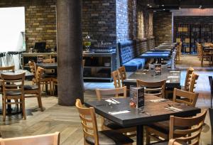 a dining room with tables and chairs and a bar at Hotel Punto MX in Mexico City