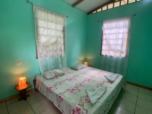 um quarto com uma cama e duas janelas em Luna Caribeña Village em Puerto Viejo