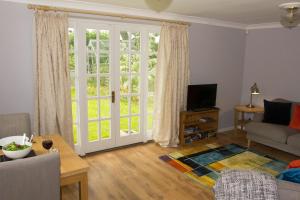 uma sala de estar com uma grande porta de vidro deslizante em Shaftesbury Modern Annexe em Shaftesbury