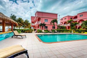 a swimming pool in front of a pink building at Seaview - Caribe Island in San Pedro