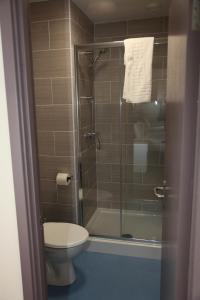 a bathroom with a toilet and a glass shower at Liberal House Tamworth in Tamworth +35 photos