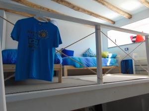 a blue t shirt hanging in a room with a bed at La Campanella Lipari in Acquacalda