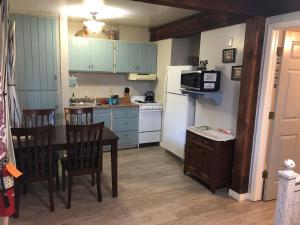 a kitchen with a table and chairs and a white refrigerator at Ramsey Canyon B&B Apartment Suites in Nicksville