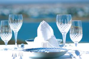 a table with three wine glasses and a plate at Colona Castle in Lakeside