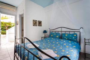 a bedroom with a bed with a blue comforter at Villa Christina in Spetses