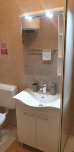 a bathroom with a white sink and a toilet at Apartments Coko in Omiš