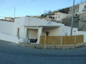 a white house with a fence in front of it at La Campanella Lipari in Acquacalda
