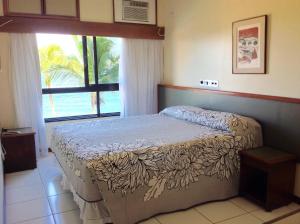 a bedroom with a bed and a large window at Ondina Apart Hotel AP in Salvador +54 photos