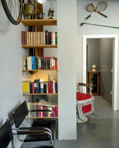 ein Zimmer mit einem Stuhl und einem Bücherregal mit Büchern in der Unterkunft Acolá Hostel in Pontevedra