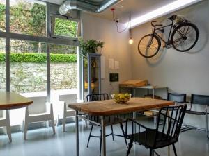 a dining room with a table and a bike on the wall at Acolá Hostel in Pontevedra