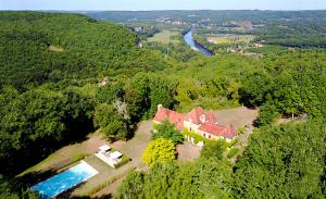una vista aérea de una casa en medio de un bosque en Le Manoir du Rocher, en Domme