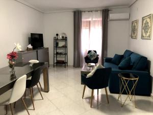 a living room with a blue couch and a table at SC Victoria II in Cáceres