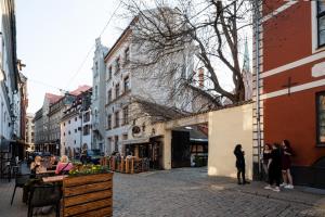 Un gruppo di persone in piedi in una strada di città di Old Riga Aldaru street 2 Level Apartment With Terrace a Riga