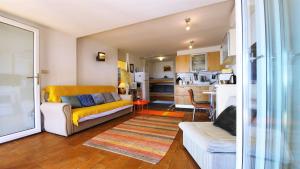 a living room with a couch and a kitchen at Mediterranean Beach House in Umag