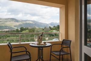 un tavolo con 2 sedie e una bottiglia di vino sul balcone di Sky Apartments & Rooms a Cavtat