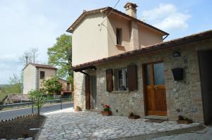 a house with a stone walkway in front of it at La Casetta della letizia in Colle