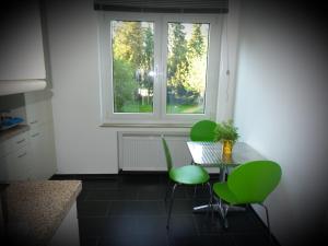 eine Küche mit einem Tisch, grünen Stühlen und einem Fenster in der Unterkunft Erdgeschosswohnung im Stadtzentrum in Kleve