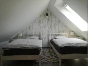 Duas camas num quarto com um sótão em Apartment Kokoro em Bogojina