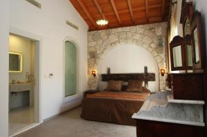 a bedroom with a bed and a stone wall at Alacati Kostem Hotel - Special Category in Alaçatı