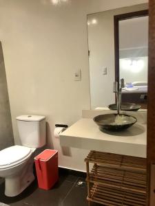 uma casa de banho com um lavatório, um WC e um espelho. em Biergarten Suites em Abraão