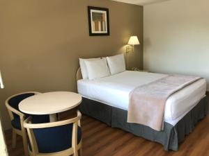 a hotel room with a bed and a small table at Sea-Tac Airport Value Inn in SeaTac