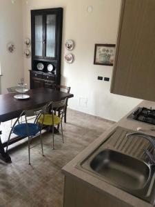 - une cuisine avec un évier, une table et des chaises dans l'établissement Casa Virginia / Virginia's Home in Turin - Casalborgone, à Casalborgone