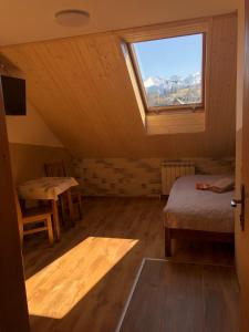 a attic room with a window and a bed and a table at U Lampy in Zakopane