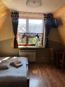 a bedroom with a bed and a window and a table at U Lampy in Zakopane