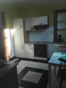 雅萊的住宿－LA DILIGENCE，厨房配有白色橱柜和炉灶。
